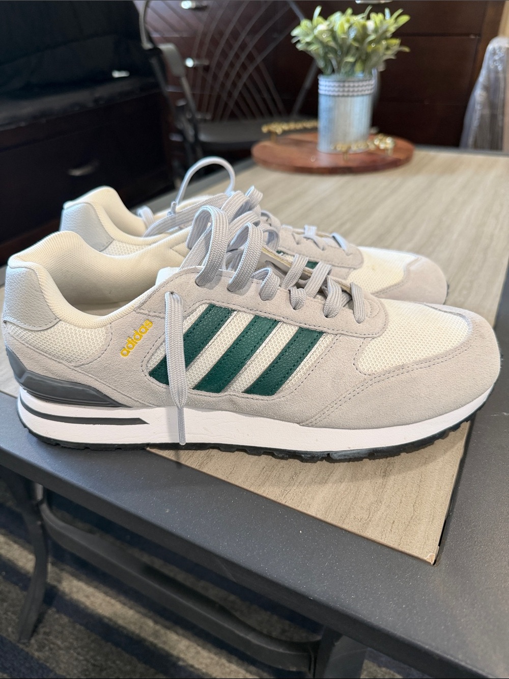 adidas Men's Light Gray Sneakers with Green Stripes does have a small stain
